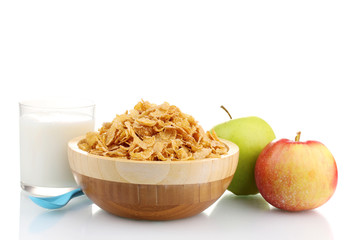 tasty cornflakes in wooden bowl, apples and glass of milk