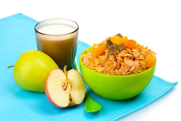 tasty cornflakes in green bowl, apples and glass of milk