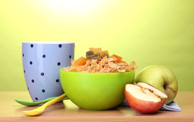 tasty cornflakes in green bowl, apples and glass of milk