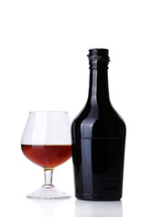 Glass of brandy and bottle isolated on white