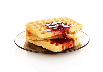 Tasty waffles with jam on plate isolated on white