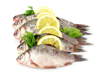 Fresh fishes with lemon and parsley isolated on white