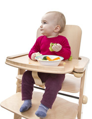 young child eating in high chair