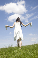 草原を歩く女性の後ろ姿