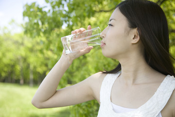 グラスで水を飲む女性