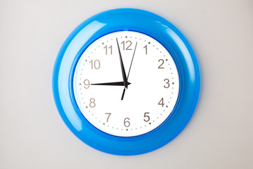 blue office clock on grey wall