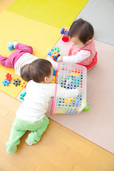 おもちゃで遊ぶ乳児3人