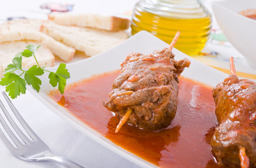 Meat roulade on white dish.