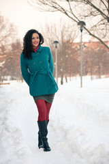 Portrait of beautiful girl in winter time walking in the snow.