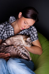 Young woman with cat, relaxed on the beanbag