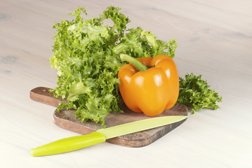 paprika and salad on cutting board on the table