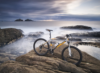 Fototapeta premium Mountain biking and rock on the sea coast