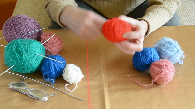 grandmother hands rolling threads in the ball