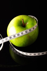 green apple surrounded by white tapeline