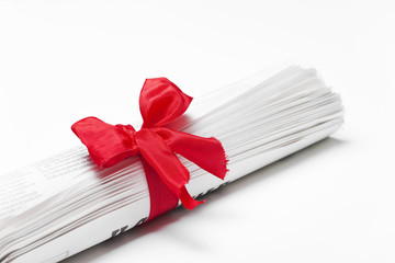 Newspaper on white background with red bow