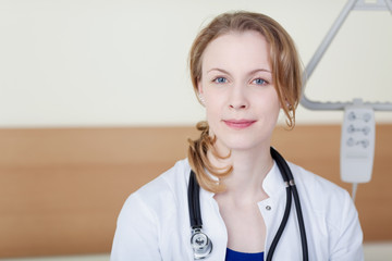 eine junge ärztin sitzt im krankenzimmer