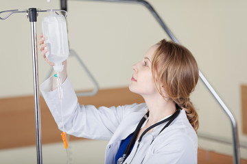 eine krankenschwester hängt die infusion auf