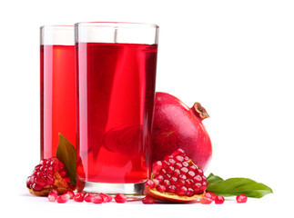 ripe pomergranate and glasses of juice isolated on white.