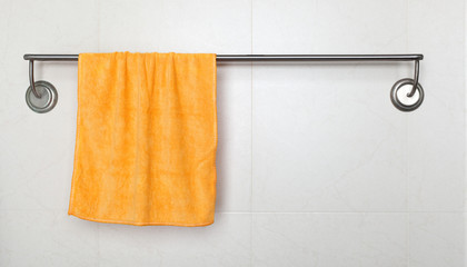 Orange microfiber towel hanging on a rack in a bathroom