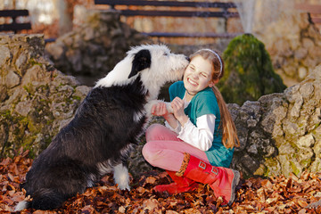 dog is kissing young girl