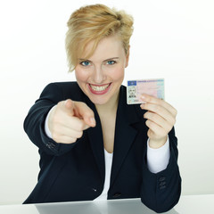 Young woman proudly presents her driver license