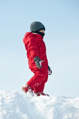 Fototapeta na wymiar Young kid playing on the snow.