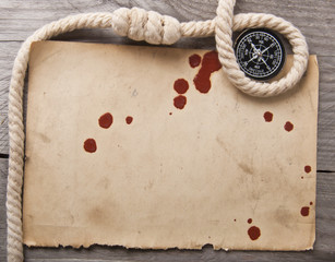 old compass, rope and an old paper on wooden background