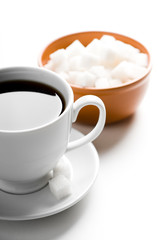 Cup of coffee and plate with sugar