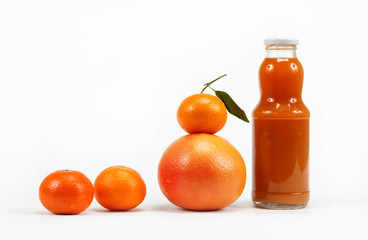 Juice in a glass bottle and tropical fruits on a white backgroun