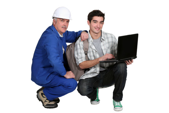 A tradesman helping his apprentice write a report