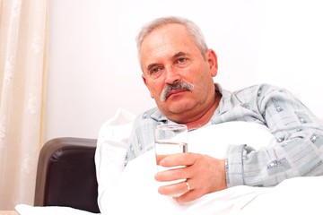 Elderly man laying in bed