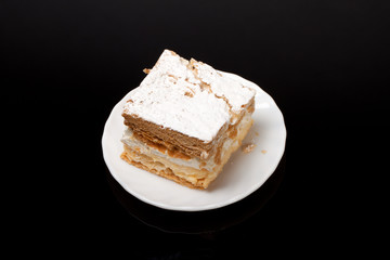 sweet  cake with cream isolated on black