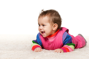 Baby girl is lying on the carpet