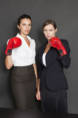 Zwei Geschäftsfrauen mit roten Boxhandschuhen