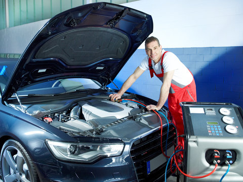 Motor mechanic working on engine bay with air handling unit