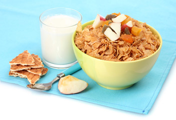 tasty cornflakes in bowl with dried fruits and glass of milk