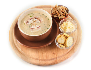 Tasty soup on wooden round board isolated on white