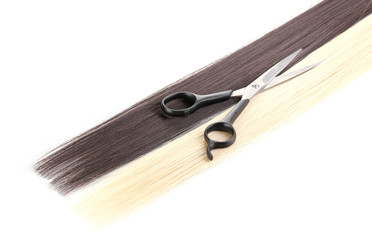 Shiny blond and brown hair with hair cutting shears isolated