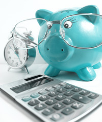 Business concept-piggy bank with glasses,calculator and a clock