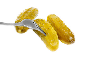 Marinated cornichons on the fork isolated on the white