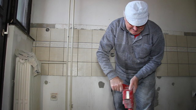 Senior man mixing adhesive for ceramic tiles
