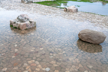 stone and column ruin in puddle