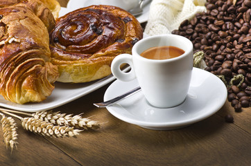 Coffee cup with a croissant and fresh coffee