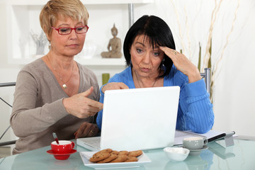 Older women puzzling over a laptop