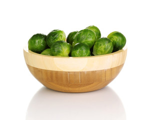 Brussels sprouts in wooden bowl isolated on white