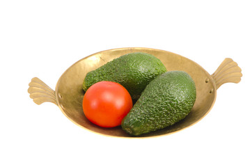 isolated brass plate with avocado and tomato