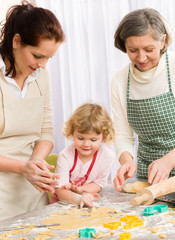 Little girl with mother cutting out cookies