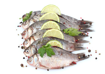 Fresh fishes with lime, parsley and spice isolated on white