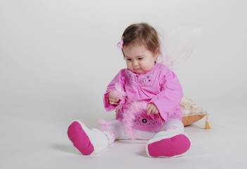 The small beautiful girl in pink clothes on a white background