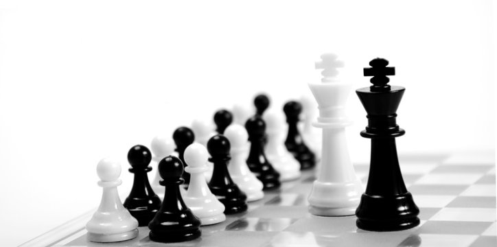 White and black king on the chessboard opposing each other